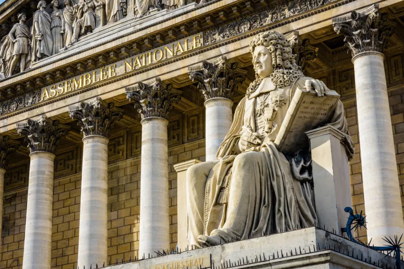 low angle view of the statue of francois d'aguesseau in front of the neoclassical facade of the palais bourbon, seat of the french national assembly in paris, france