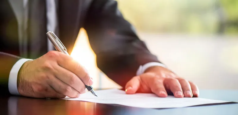 businessman signing a legal document
