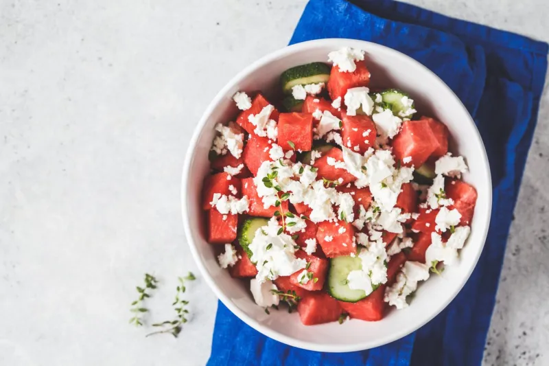 watermelon, cucumber and feta cheese salad in white bowl, copy space