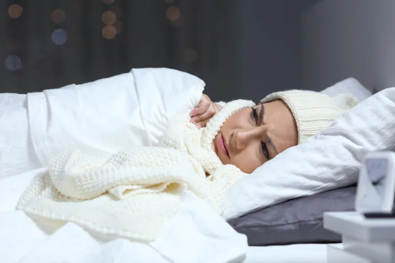 angry woman suffering cold complaining in a bed in winter