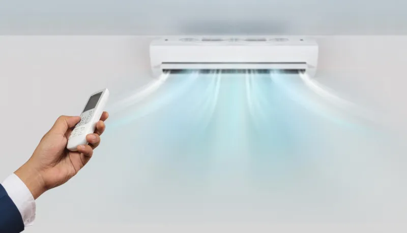 hand with remote control directed and air conditioner