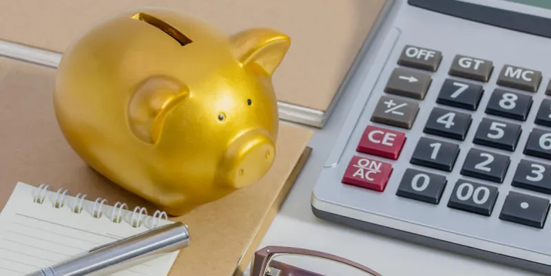 cochon tirelire, calculatrice, téléphone, ordinateur portable, stylo, lunettes, concept d'économiser de l'argent