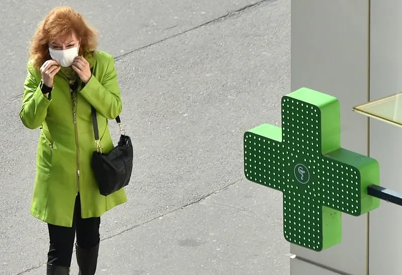 a woman straightens her face masks as she walks past a pharmacy amid the outbreak of covid-19 (novel coronavirus), in kiev on april 4, 2020 (photo by sergei supinsky   afp)