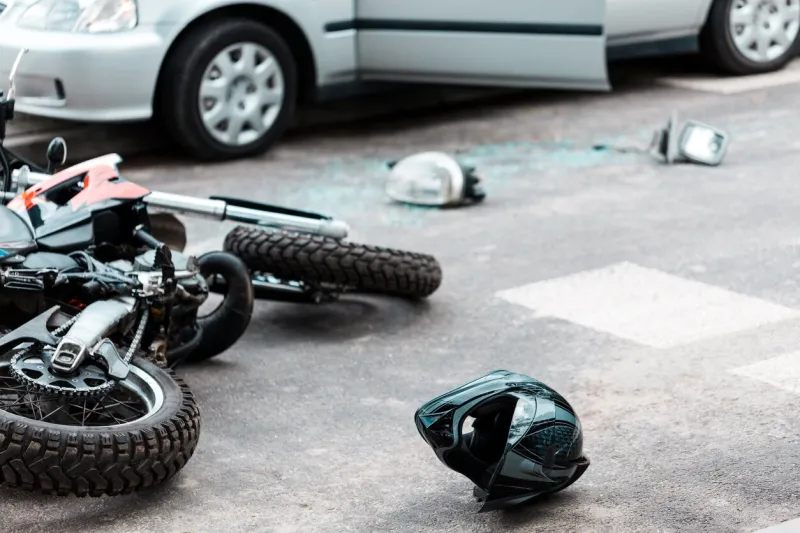 overturned motorcycle and helmet on the street after collision with the car