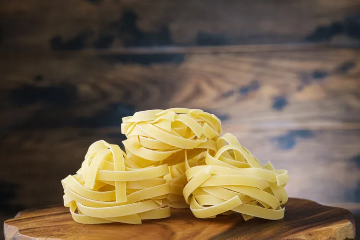 fettuccine pasta on wooden background cooking italian pasta
