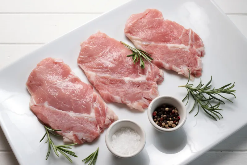 veal scaloppini with spices on a white plate directly above