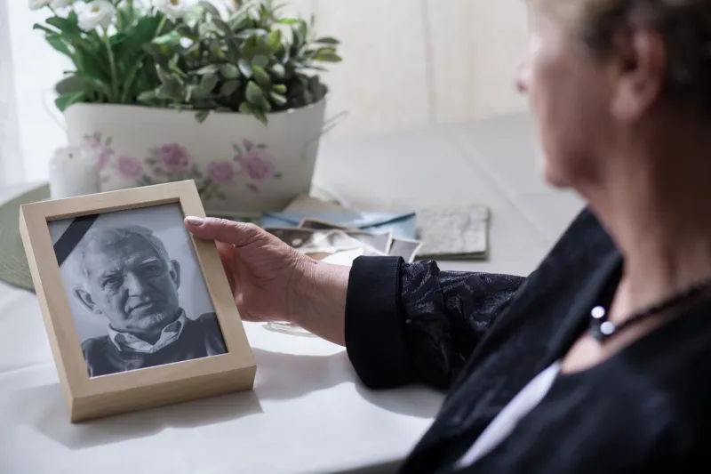 widow looking at the photo of her dead husband