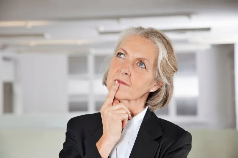 thoughtful senior businesswoman looking up in office