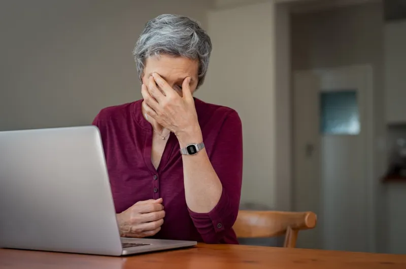 mature businesswoman suffering a stress headache sitting at her desk with closed eyes in pain senior woman thinking about to complete work task depressed tired mature lady suffering from chronic daily headache from computer
