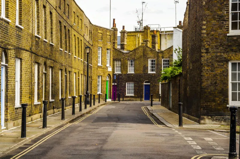 typical old english buildings, low brick buildings across a narrow street, interesting old london architecture, english houses