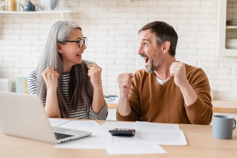 happy excited mature middle-aged couple celebrating success in paperwork, business, paying bills, lottery win, investment, start up, pension, refunds, payment, savings, budget planning concept