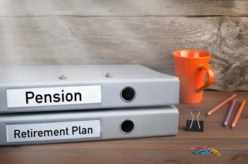 retirement plan and pension - two folders on wooden office desk