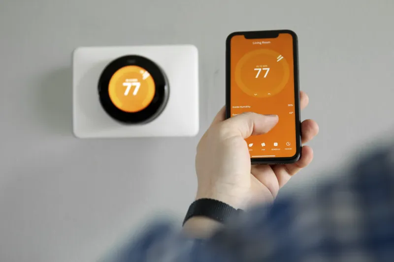 man uses a mobile phone with smart home app in modern living room