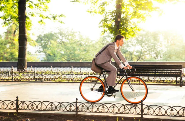bel homme d'affaires, faire du vélo pour travailler dans le parc