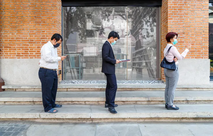 asian middle aged people wearing mask and keep social distancing to avoid the spread of covid-19