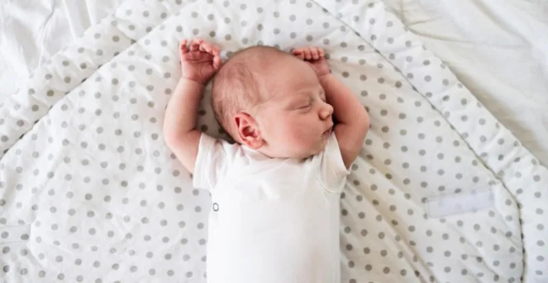 mignon petit garçon nouveau-né couché sur le lit, dormir, les mains en gros plan