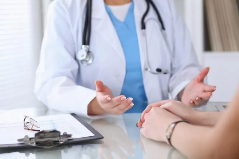 close up of a doctor and patient hands discussing something while sitting at the table medicine and health care concept
