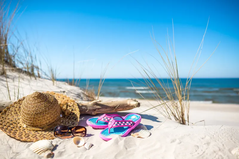 holiday concept with beach accessories on sand, summer vacation background, baltic sea, poland