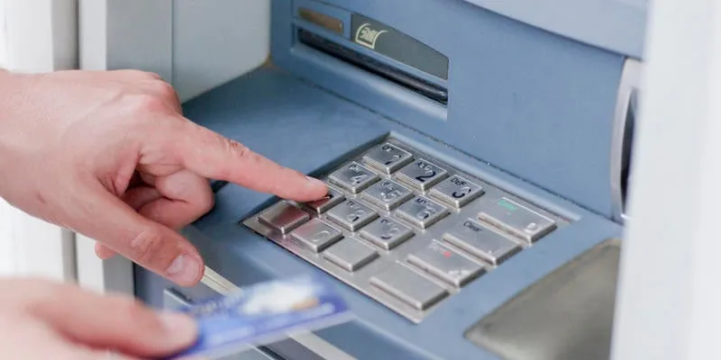 hand inserting atm card into bank machine to withdraw money businessman men hand puts credit card into atm
