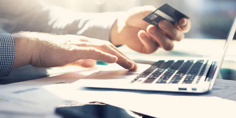 closeup businessman working with generic design notebook online payments, hands keyboard blurred background, film effect