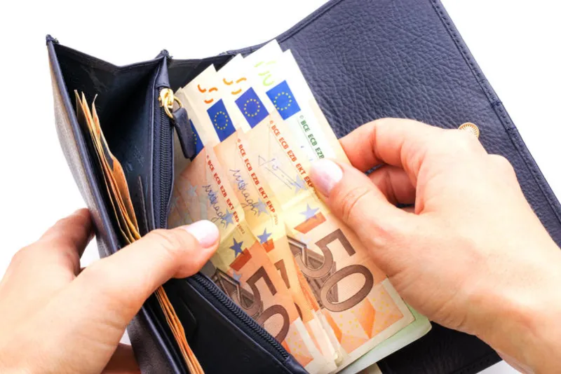 blue purse with euros in the hands isolated on a white background