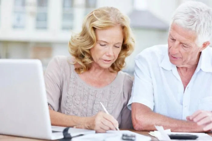 couple de personnes âgées travaillant sur leurs finances à la maison ensemble