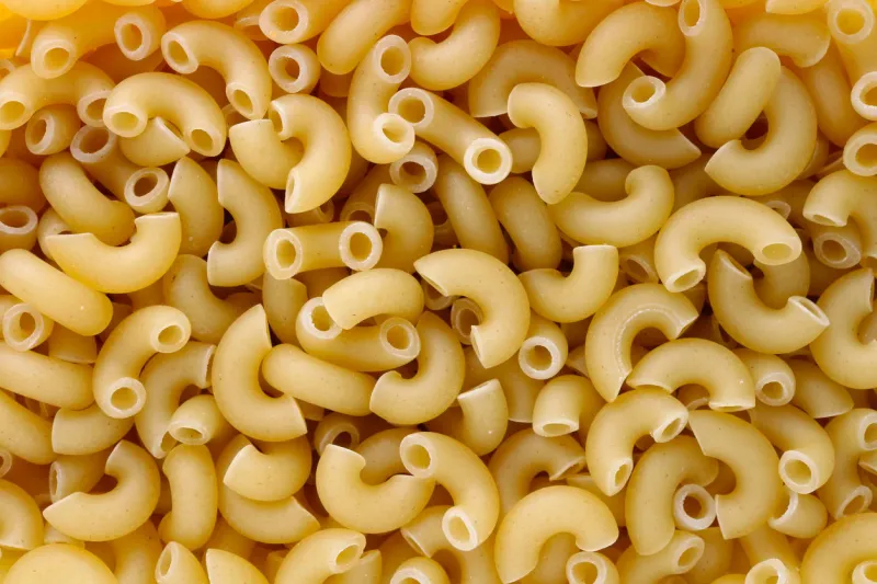 dry small pasta in the form of short half round tubes studio food macro background