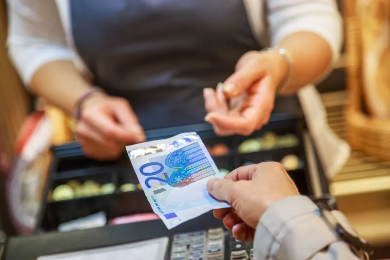 woman is paying in cash with euro banknotes