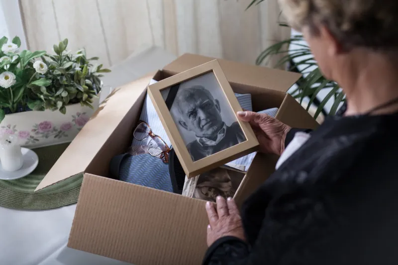 woman is packing things of her dead husband