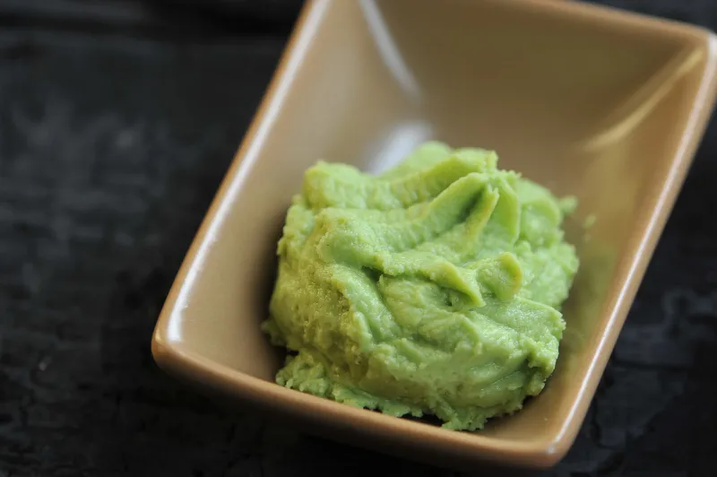 wasabi is a seasoning of japanese cuisine wasabi in a ceramic bowl dark background close-up macro shooting
