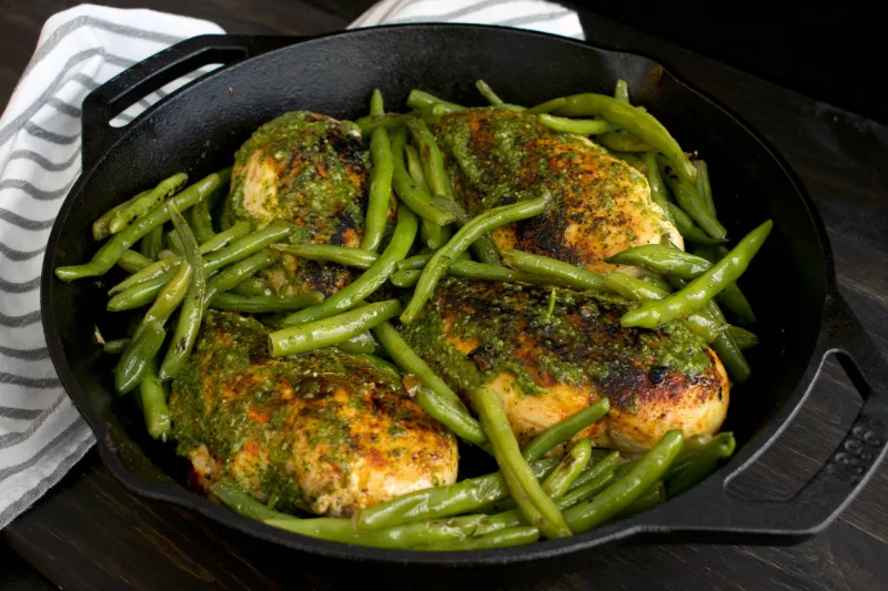 cooked chicken breasts and green beans in a cast iron skillet
