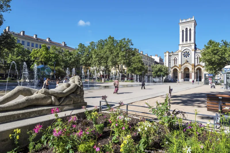 saint-etienne, france - july 29, 2019 the square of jean jaures in saint etienne downtown with fountains morini andre catholic church is at right background