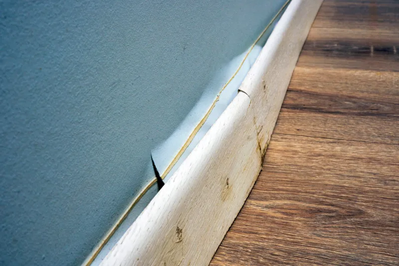 damaged skirting board detached from the wall after the apartment was flooded