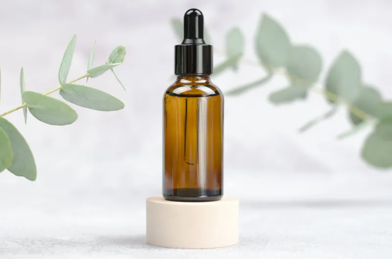 mock up glass bottle and eucalyptus a bottle of essential oil or serum on a light background natural beauty product natural eucalyptus oil