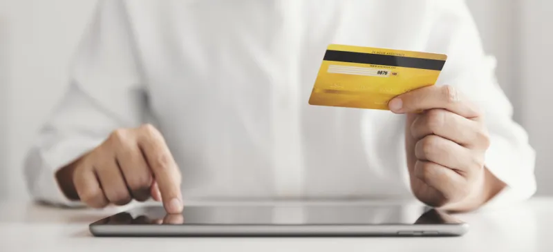 hands holding credit card and using tablet, businesswoman working at home, online shopping, e-commerce, spending money, internet banking, work from home concept (hands holding credit card and using tablet, businesswoman working at home, online shoppi