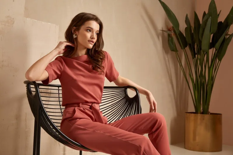 beautiful brunette woman natural makeup wear fashion clothes casual dress code office style total pink blouse and pants suit, romantic date business meeting accessory armchair interior stairs flowerpot