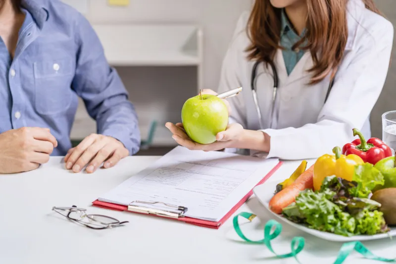 nutritionist giving consultation to patient with healthy fruit and vegetable, right nutrition and diet concept