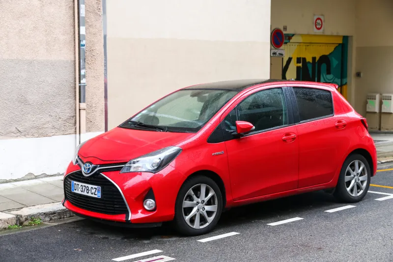 grenoble, france - march 14, 2019  red hybrid car toyota yaris in the city street