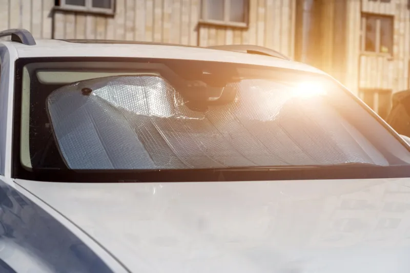 sun visor or sun reflector on car windshield protects car in parking lot there is light from sun shining on windshield