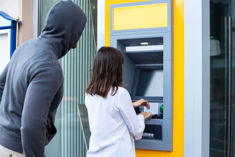 male trying to steal pin code of woman's card using atm for withdrawing cash