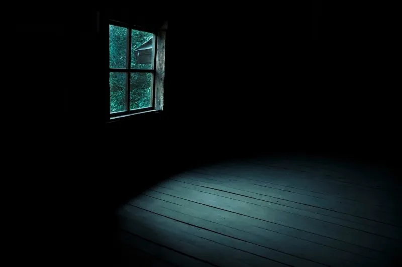 abstract horror background for halloween gloomy scary terrible window with ghostly light and shadows in a dark black room in the attic, corridor or basement in an abandoned house in the forest