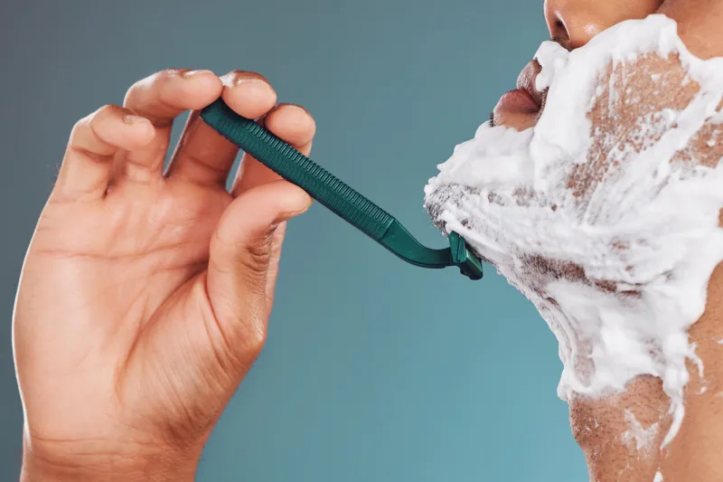 shaving foam, razor and skincare mockup with man cleaning his face with care for healthy, clean and smooth skin male in studio for dermatology, shaved beard and cosmetics for wellness and health