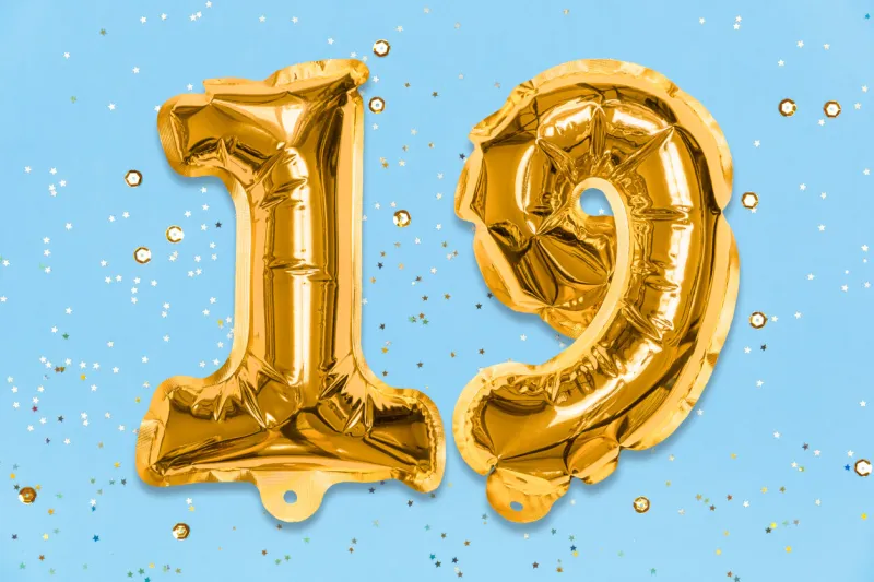 the number of the balloon made of golden foil, the number nineteen on a blue background with sequins birthday greeting card with inscription 19 numerical digit, celebration event, template