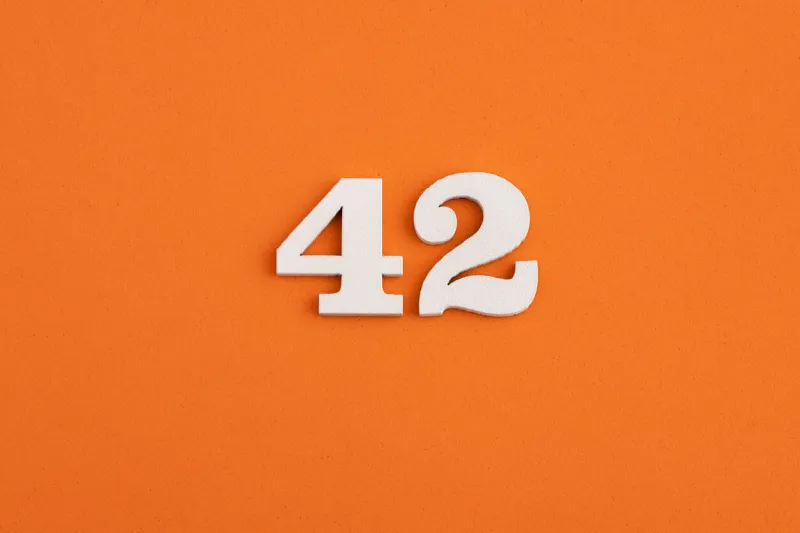 white wooden number 42 on eva rubber orange background