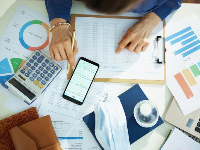 upper view of middle age business woman at the table checking emails on a smartphone