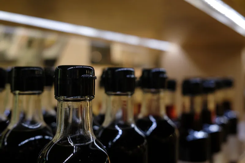rows of bottles with black liquid and black caps