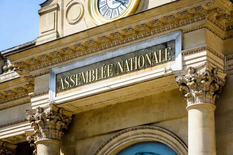 close-up view of the sign assemblee nationale in golden letters on the pediment of the southern entrance of the palais bourbon, seat of the french national assembly in paris, france, on a sunny day