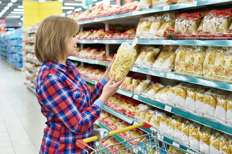 woman with a package pasta in the shop