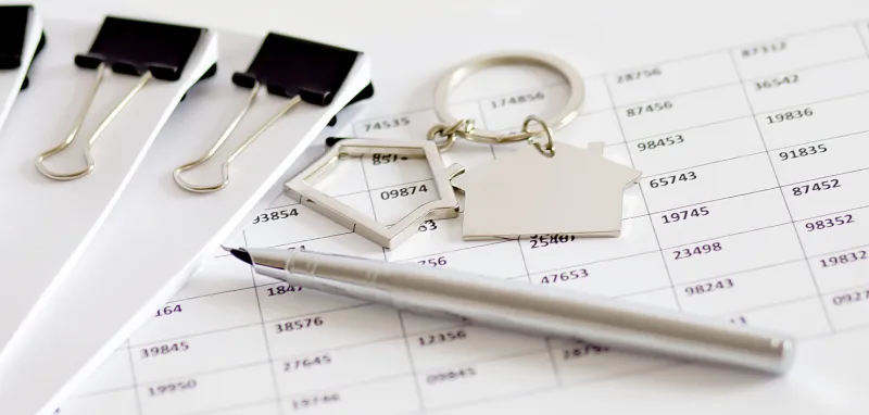 small house model keys pen on the mortgage document