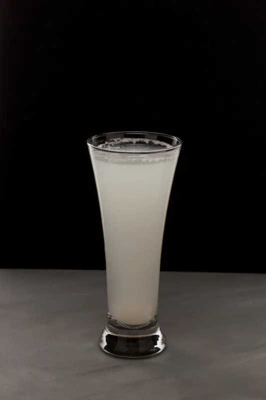milky white drink in clear glass alcoholic or non alcoholic drink on dark background with copy space